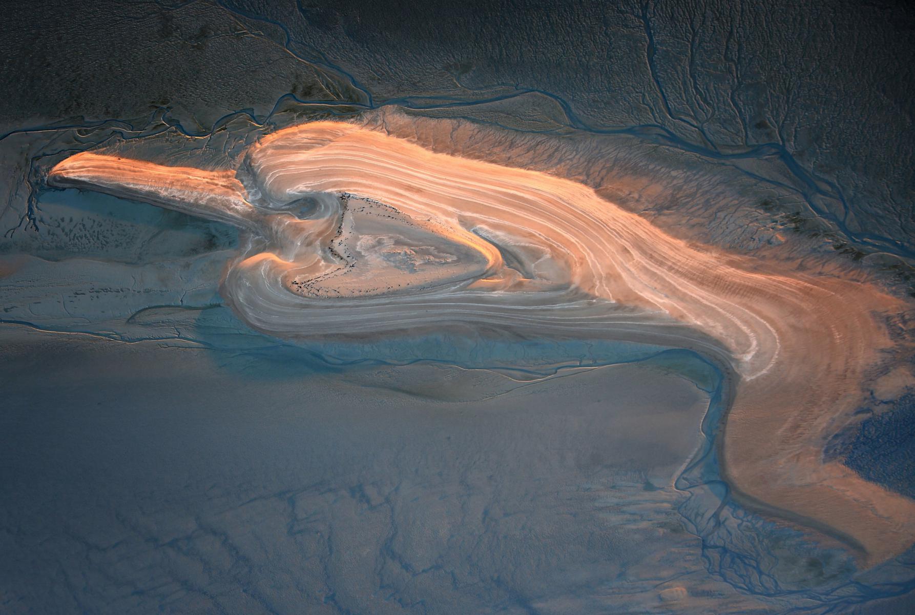 Photographie Saisissant contraste de lumière sur le banc de sable des Hermelles à Roz sur Couesnon. Une œuvre naturelle éphémère captée en Ille-et-Vilaine.