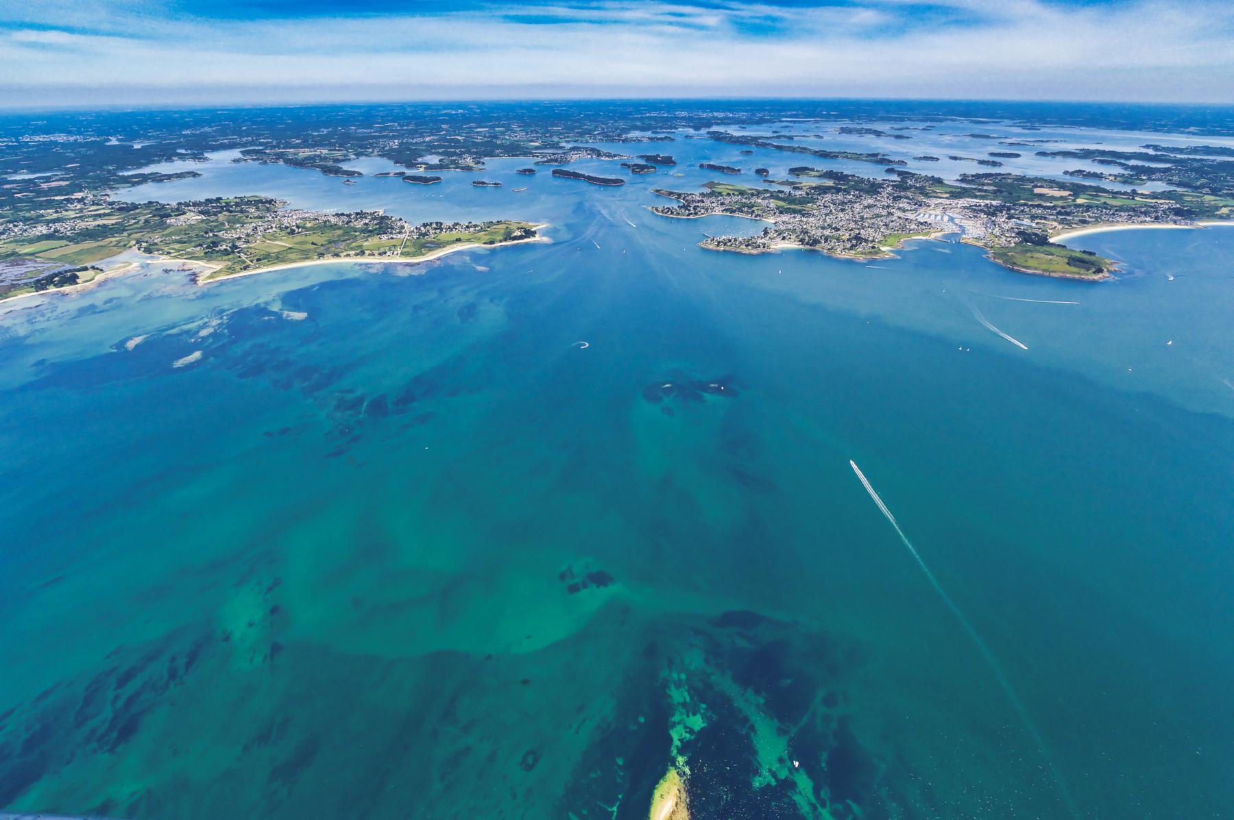 Vue du ciel des eaux turquoise et des côtes bretonnes entre Port-Navalo et Locmariaquer par un temps clair et ensoleillé.