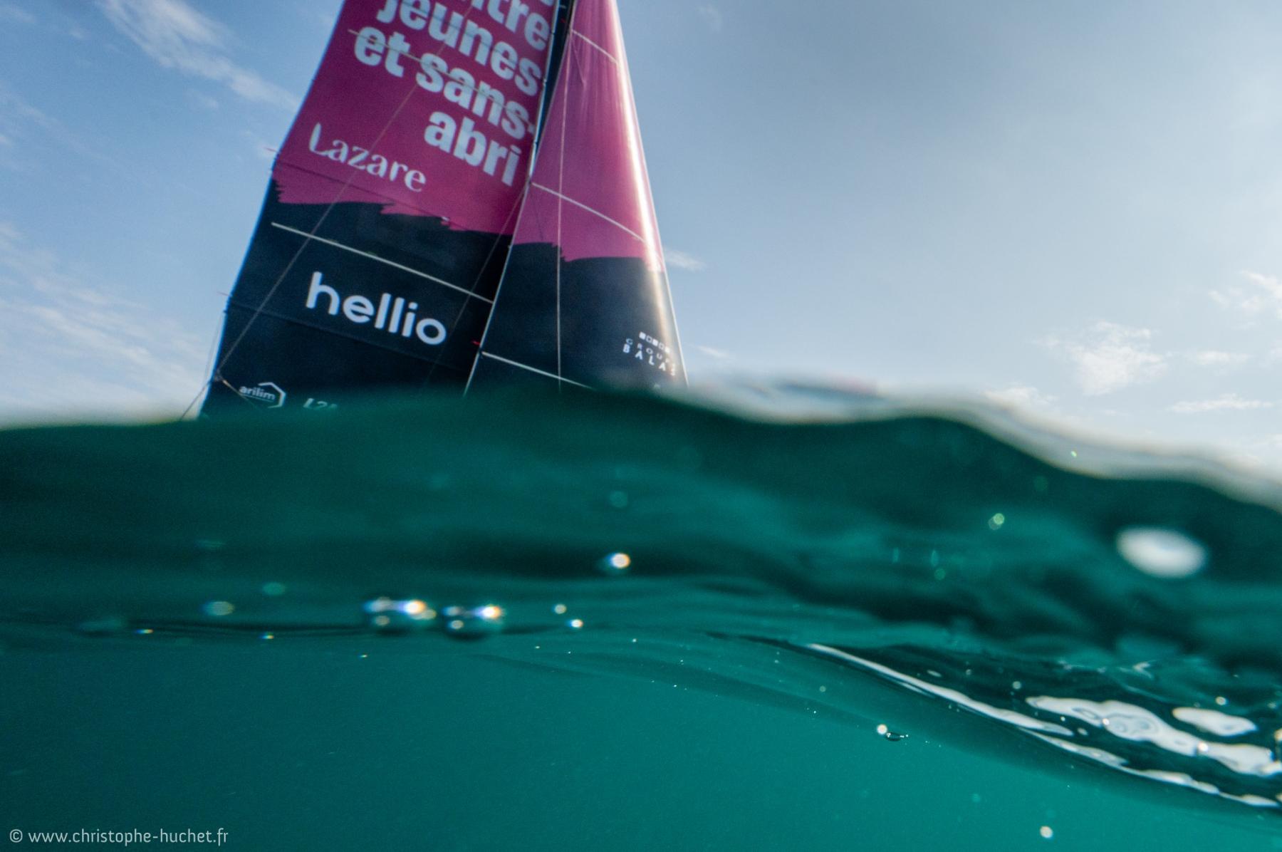 Photographie Photographe nautique et voile, je capture l'Ocean Fifty Lazare dans la pétole avec une prise de vue immergée qui laisse passer la transparence de l'eau emeraude